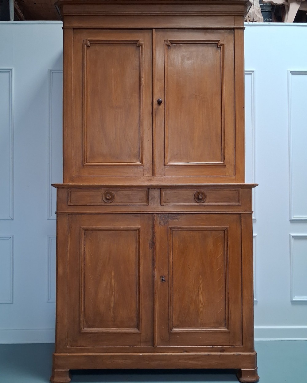 A tall mid-19th century two-tier French provincial housekeepers cupboard with painted ochre timber, panelled cupboard doors, and two central drawers. View II