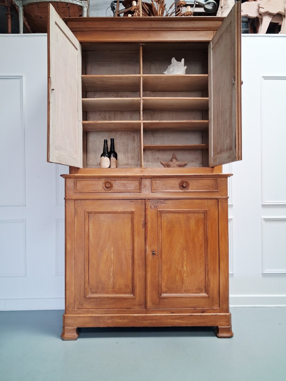A tall mid-19th century two-tier French provincial housekeepers cupboard with painted ochre timber, panelled cupboard doors, and two central drawers. View IV