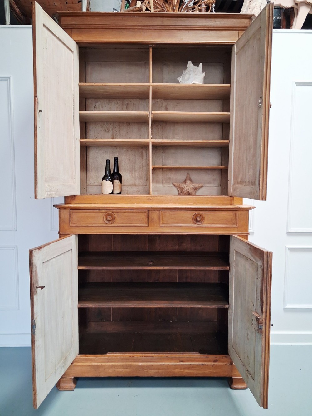 A tall mid-19th century two-tier French provincial housekeepers cupboard with painted ochre timber, panelled cupboard doors, and two central drawers. View V