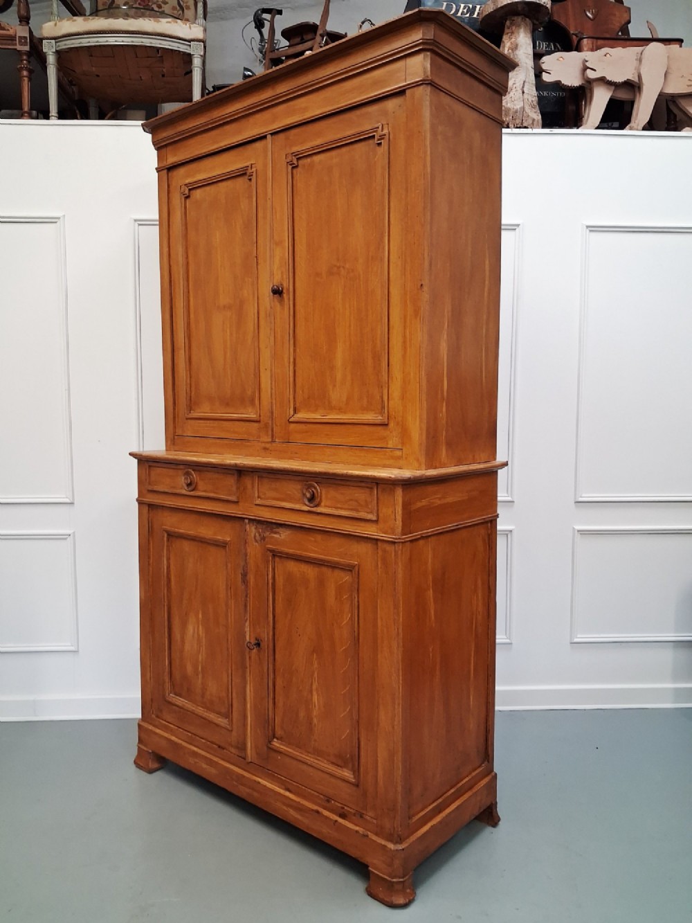 A tall mid-19th century two-tier French provincial housekeepers cupboard with painted ochre timber, panelled cupboard doors, and two central drawers. View IX