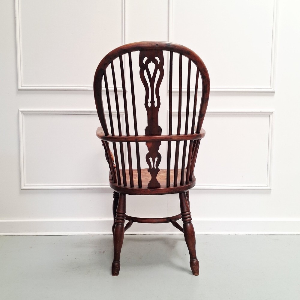 Side view of a mid-19th-century wooden Windsor armchair featuring turned front legs, spindle back, and shaped armrests. View II