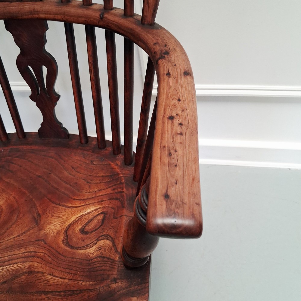 Side view of a mid-19th-century wooden Windsor armchair featuring turned front legs, spindle back, and shaped armrests. View V
