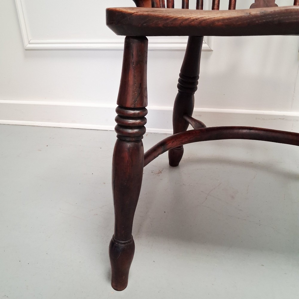 Side view of a mid-19th-century wooden Windsor armchair featuring turned front legs, spindle back, and shaped armrests. View VII
