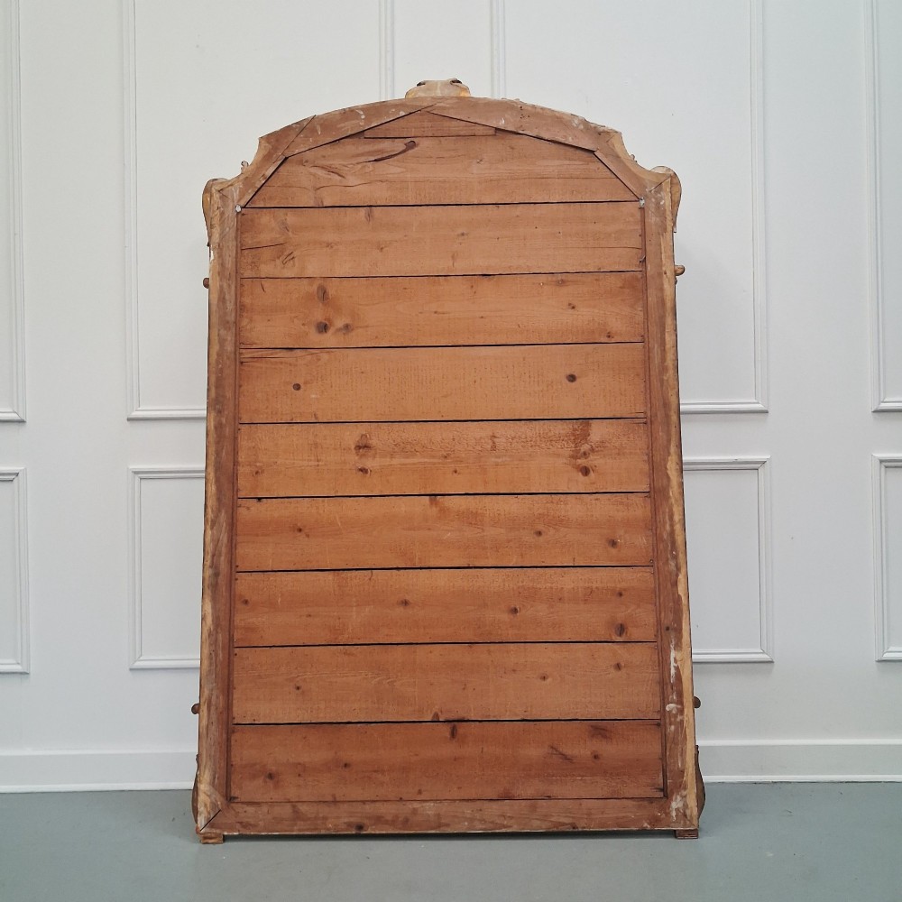 A large nineteenth-century French arched mirror with a gold giltwood frame and ornate carved floral cresting. View II
