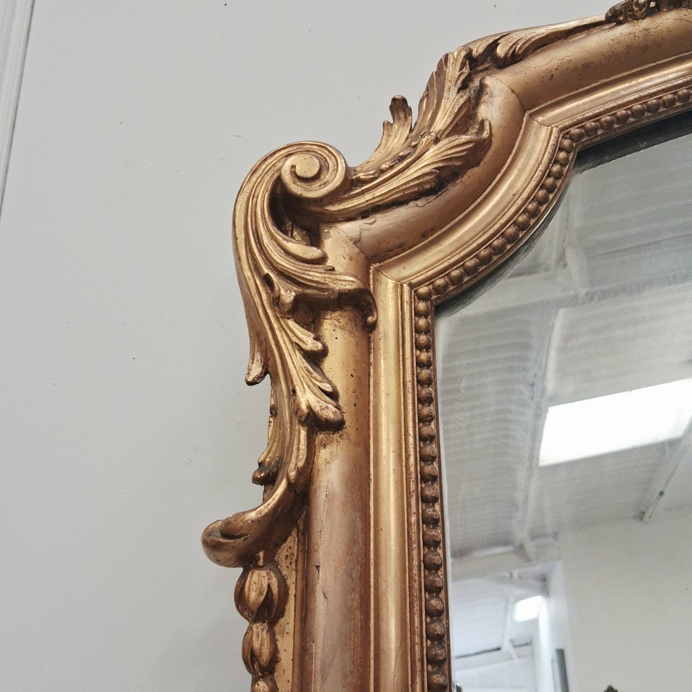 A large nineteenth-century French arched mirror with a gold giltwood frame and ornate carved floral cresting. View VIII