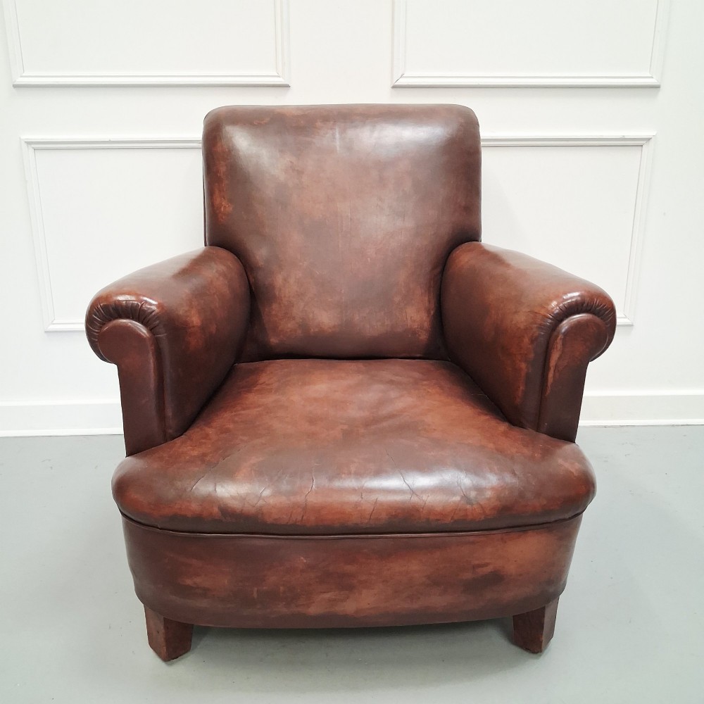 A pair of 1930s French club chairs upholstered in warm brown leather with rolled arms and short wooden feet. View VIII