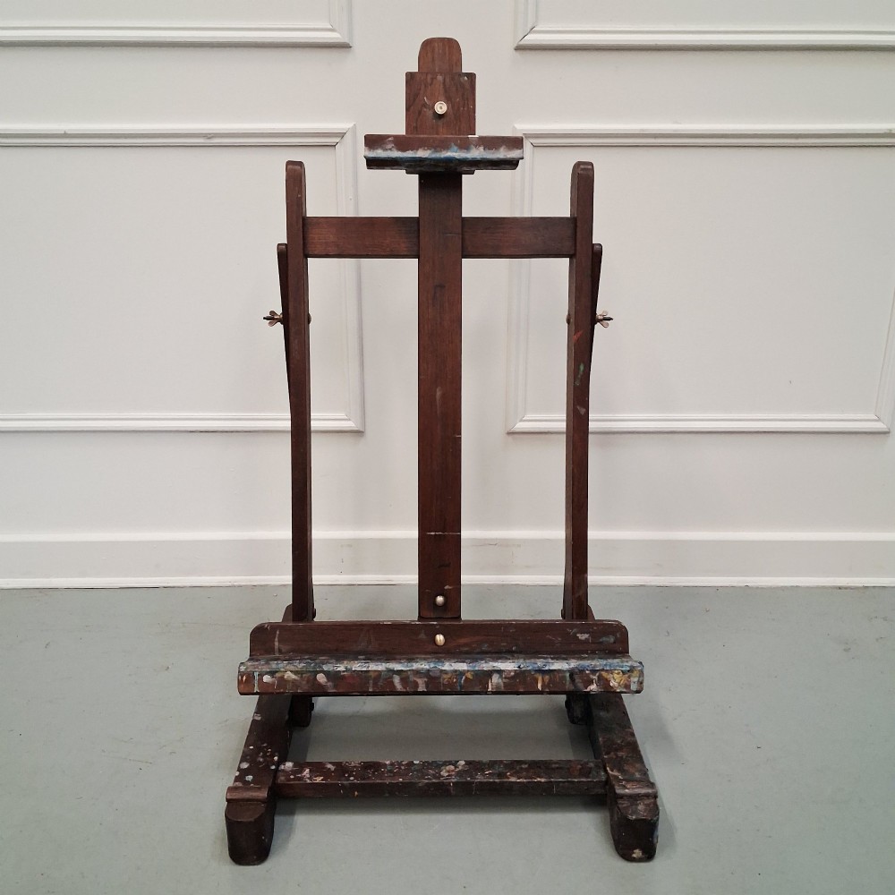 A dark oak French tabletop easel from circa 1930 featuring paint splatter details along the adjustable support ledge and central vertical frame.