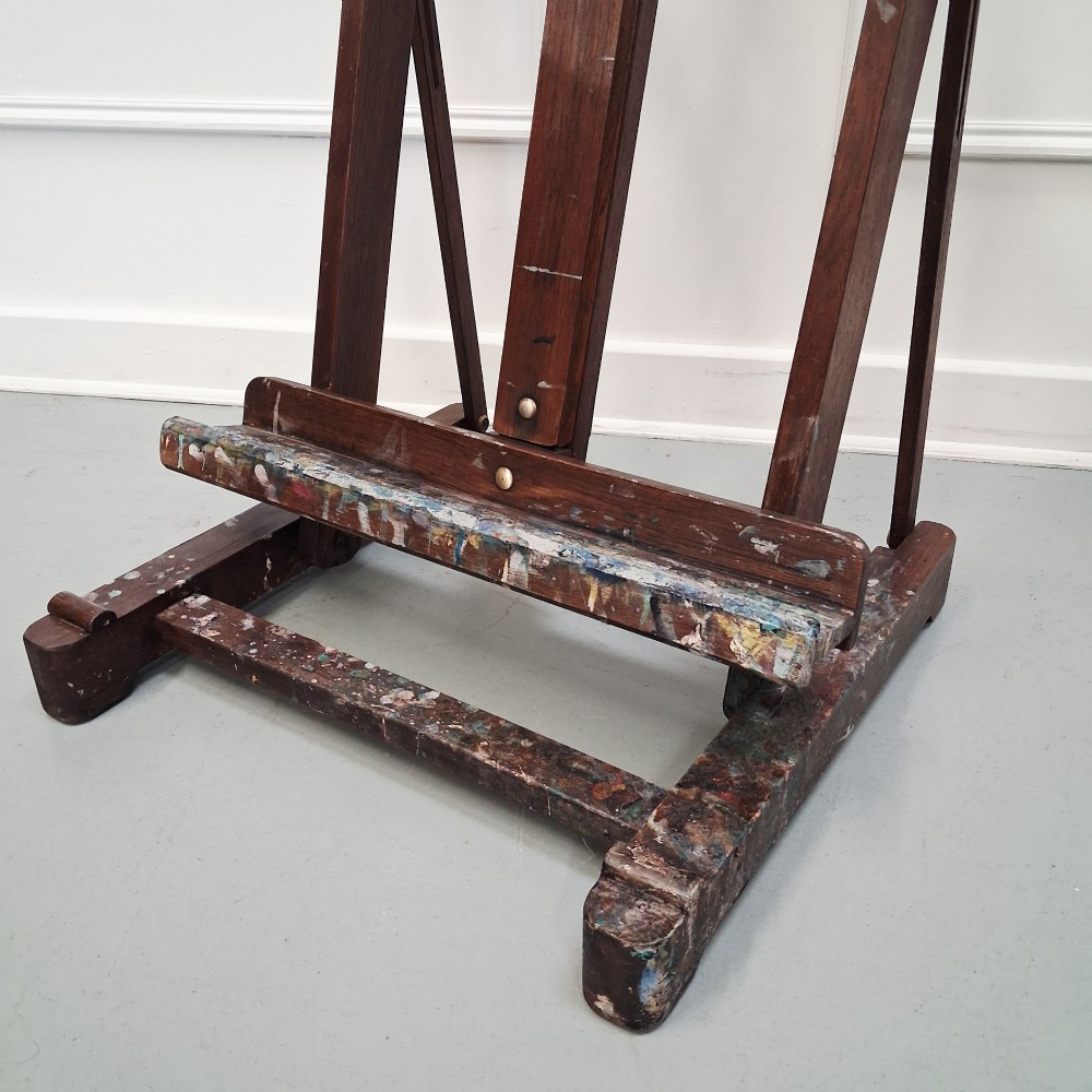 A dark oak French tabletop easel from circa 1930 featuring paint splatter details along the adjustable support ledge and central vertical frame. View II