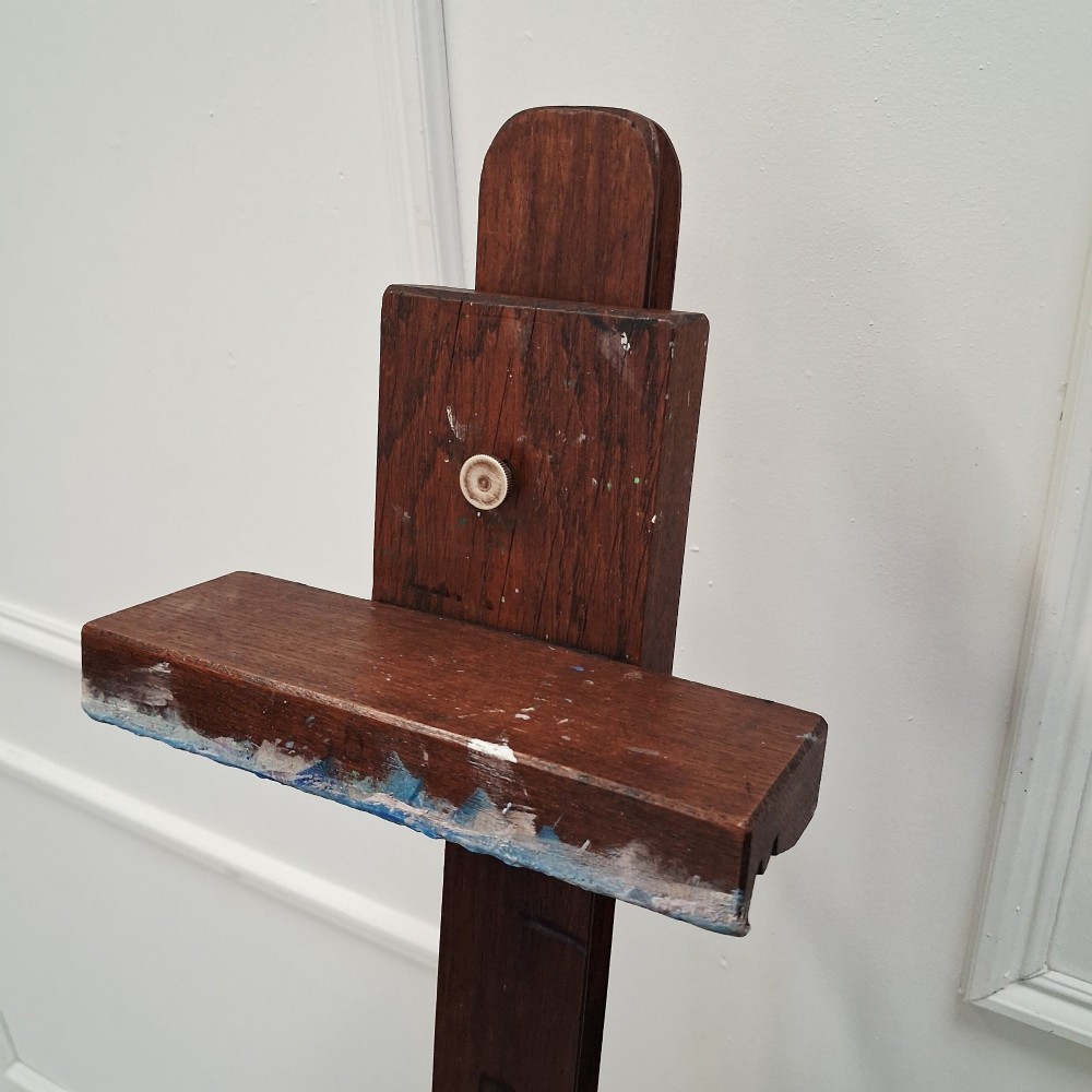 A dark oak French tabletop easel from circa 1930 featuring paint splatter details along the adjustable support ledge and central vertical frame. View X