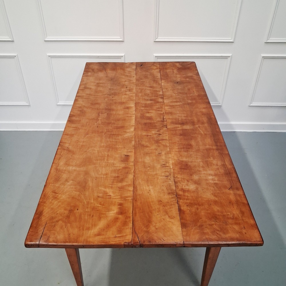 An antique 19th-century satin birch farmhouse table featuring a rectangular plank top, deep apron, and four square tapered legs. View IV