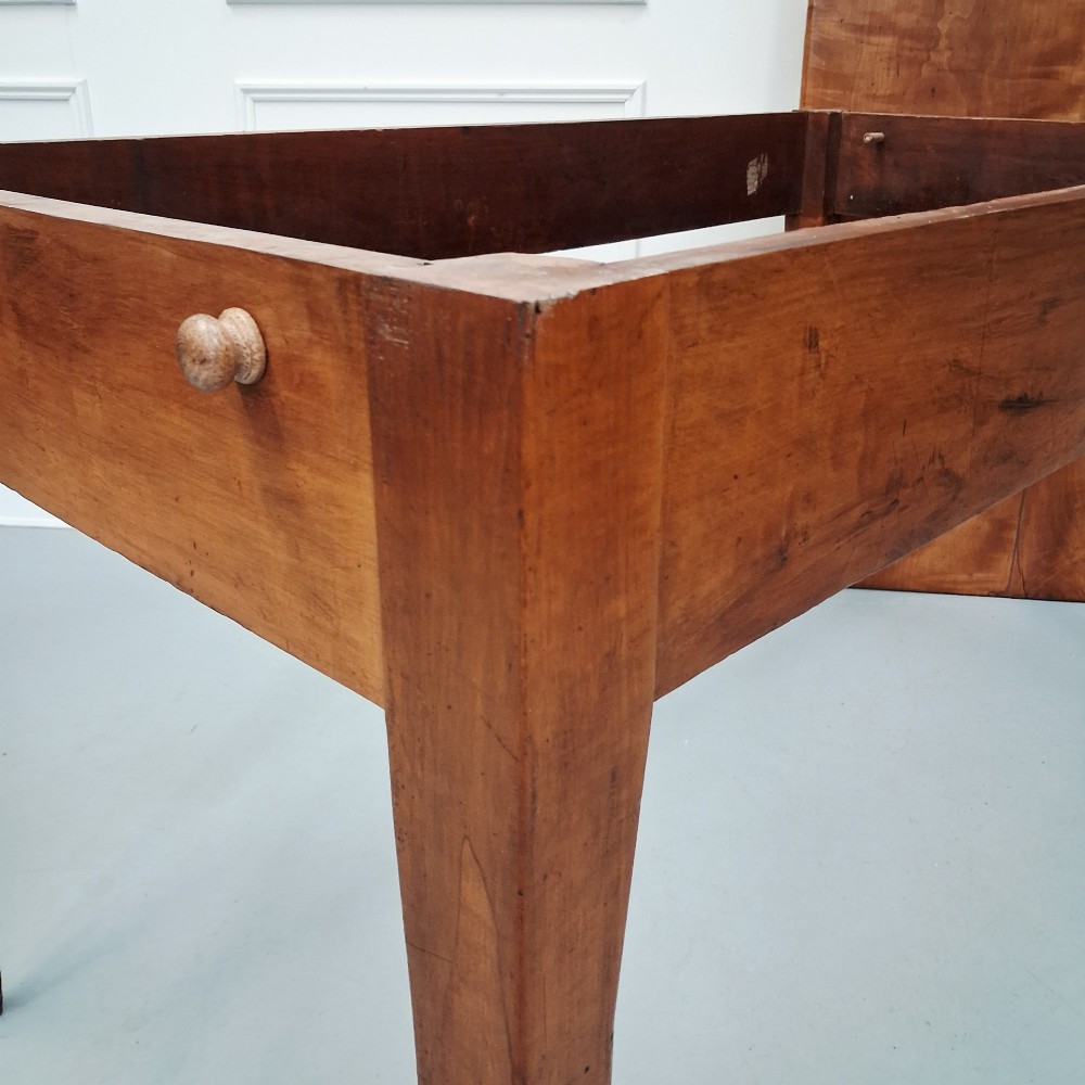 An antique 19th-century satin birch farmhouse table featuring a rectangular plank top, deep apron, and four square tapered legs. View X