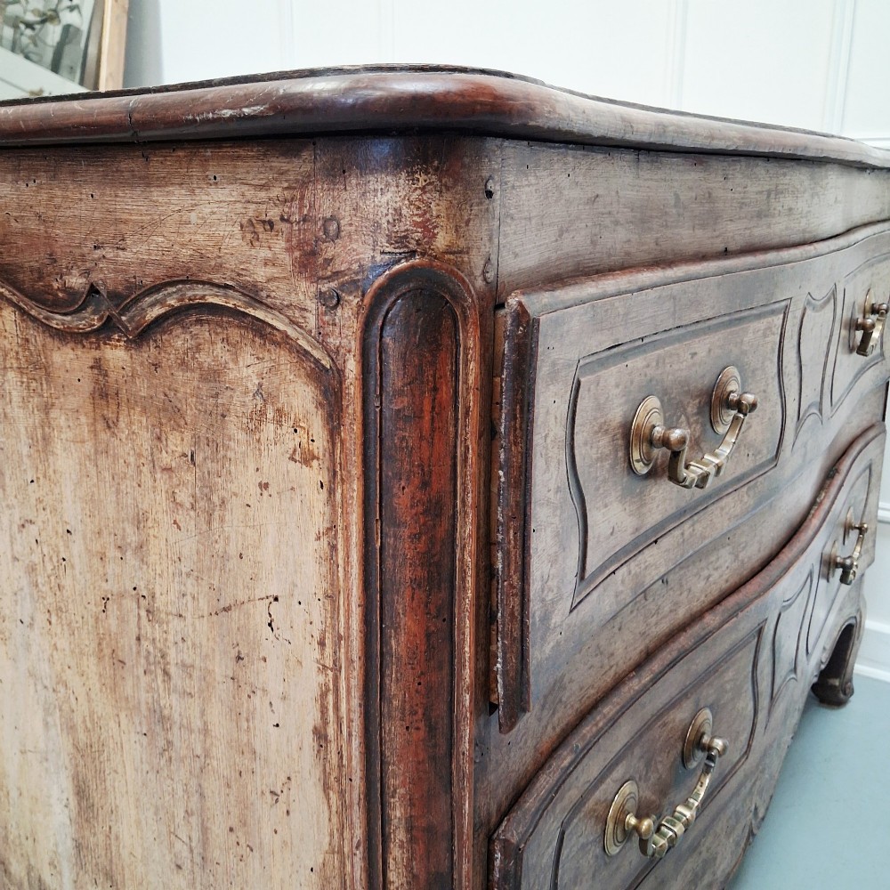 An antique French oak commode featuring two wide drawers with carved moulded panel details, brass drop handles, a scalloped lower apron, and short cabriole feet. View VI