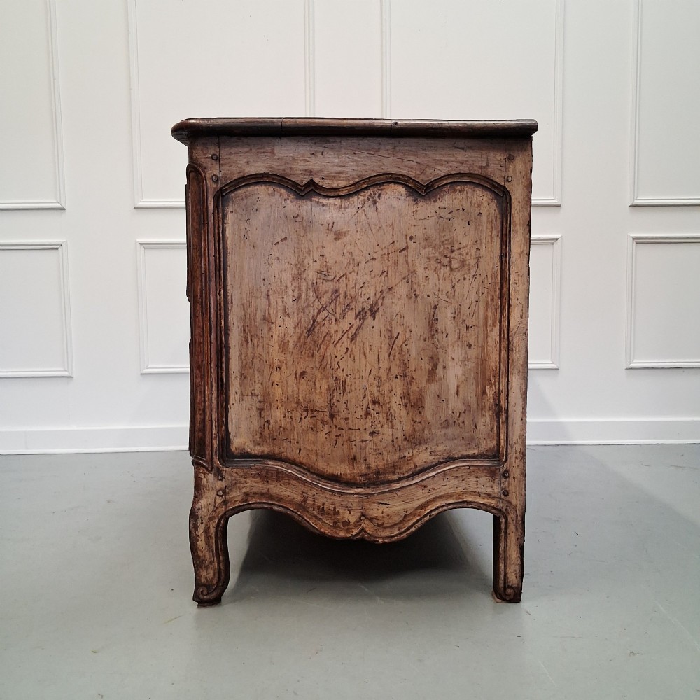 An antique French oak commode featuring two wide drawers with carved moulded panel details, brass drop handles, a scalloped lower apron, and short cabriole feet. View X