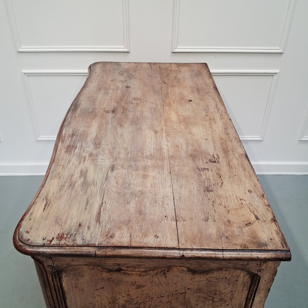 An antique French oak commode featuring two wide drawers with carved moulded panel details, brass drop handles, a scalloped lower apron, and short cabriole feet. View XI