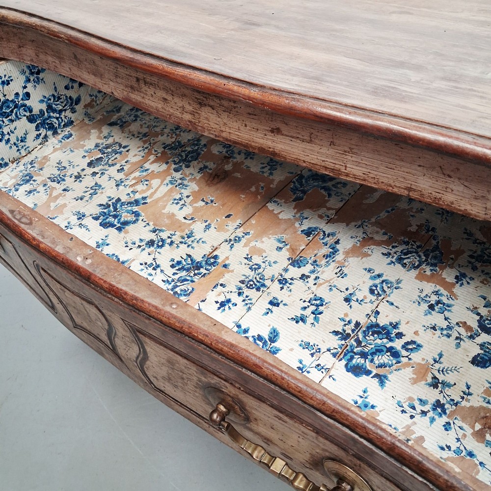 An antique French oak commode featuring two wide drawers with carved moulded panel details, brass drop handles, a scalloped lower apron, and short cabriole feet. View XIV