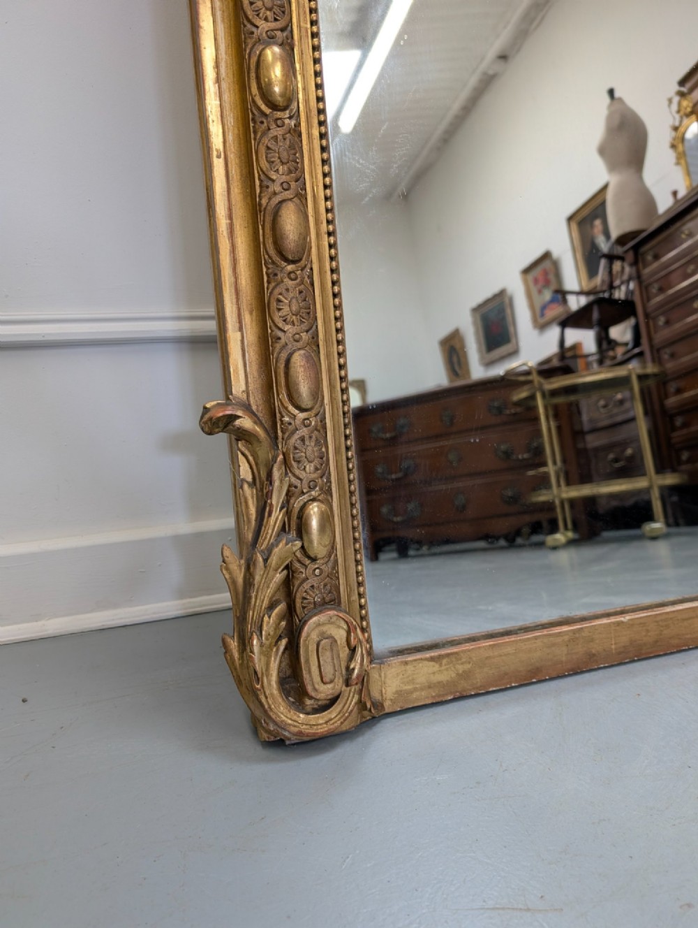 A large nineteenth-century French gilded mirror featuring an arched frame topped with an intricate ribbon crest and beaded border moulding. View II