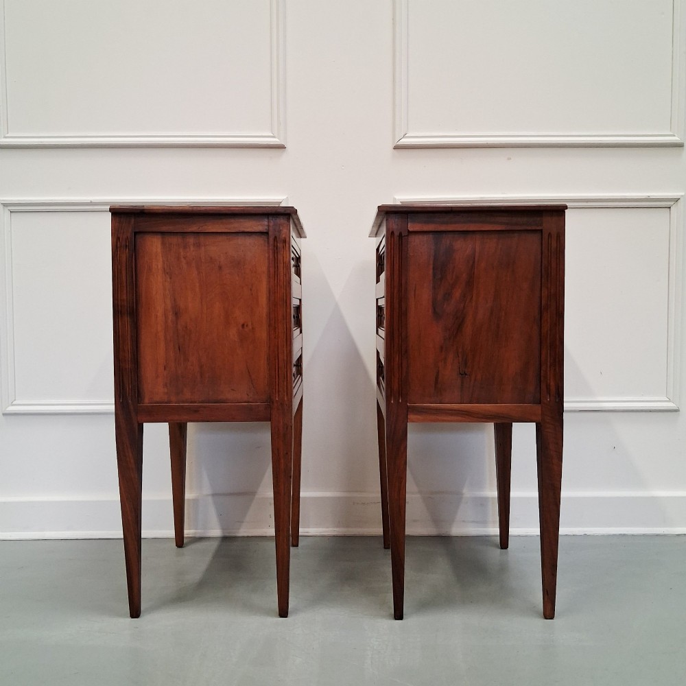 A pair of French antique walnut bedside tables with three drawers and slender tapered legs. View II
