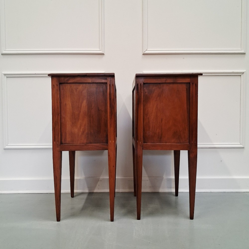 A pair of French antique walnut bedside tables with three drawers and slender tapered legs. View V