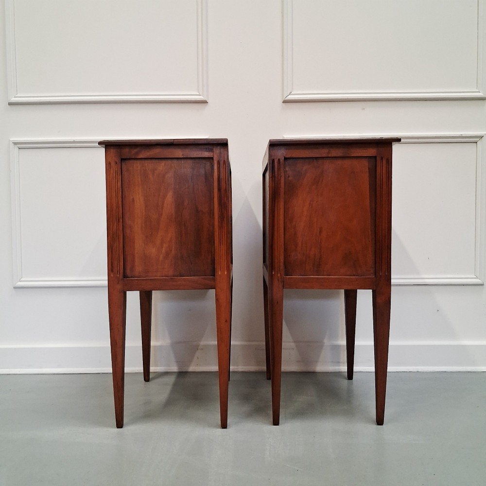 A pair of French antique walnut bedside tables with three drawers and slender tapered legs. View VI