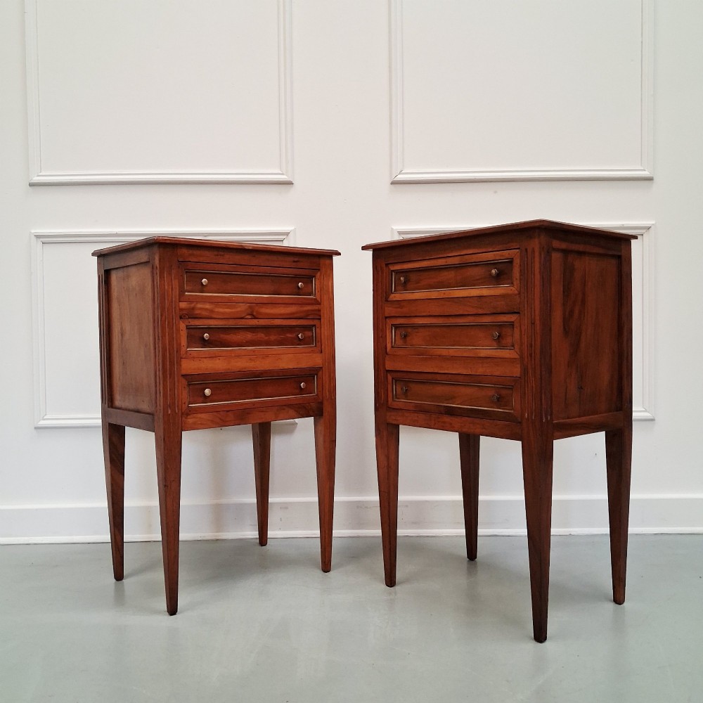 A pair of French antique walnut bedside tables with three drawers and slender tapered legs. View VII