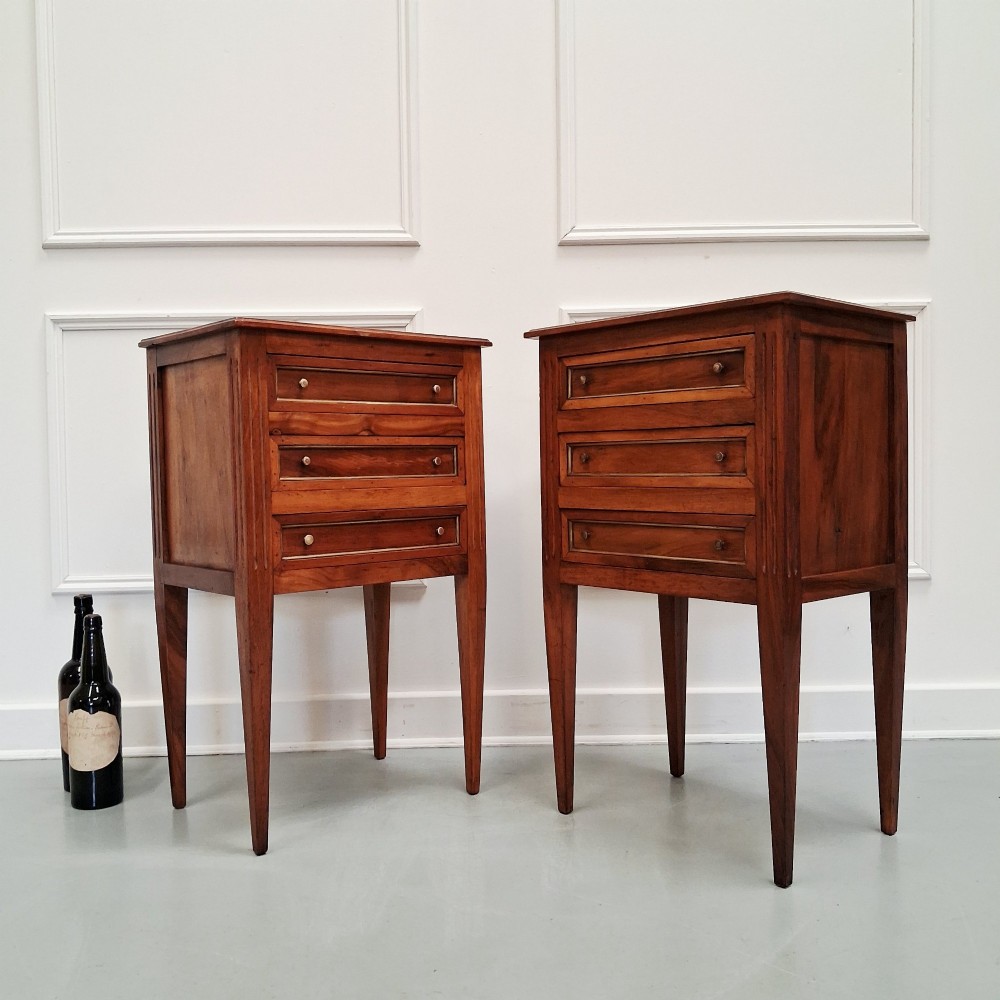 A pair of French antique walnut bedside tables with three drawers and slender tapered legs. View VIII