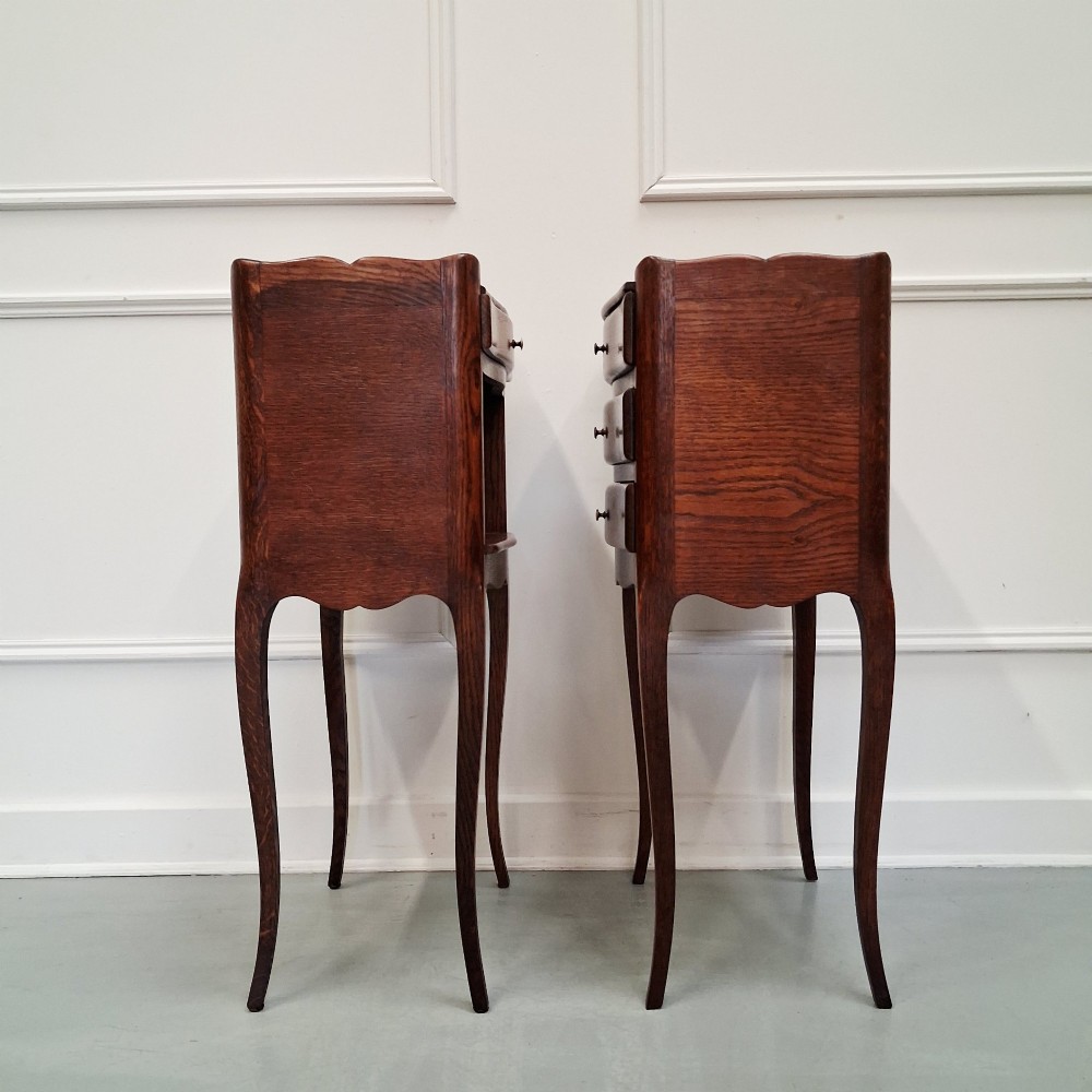 A pair of 1930s French oak bedside tables with slender cabriole legs, one featuring three drawers and the other featuring a single drawer above an open compartment. View II