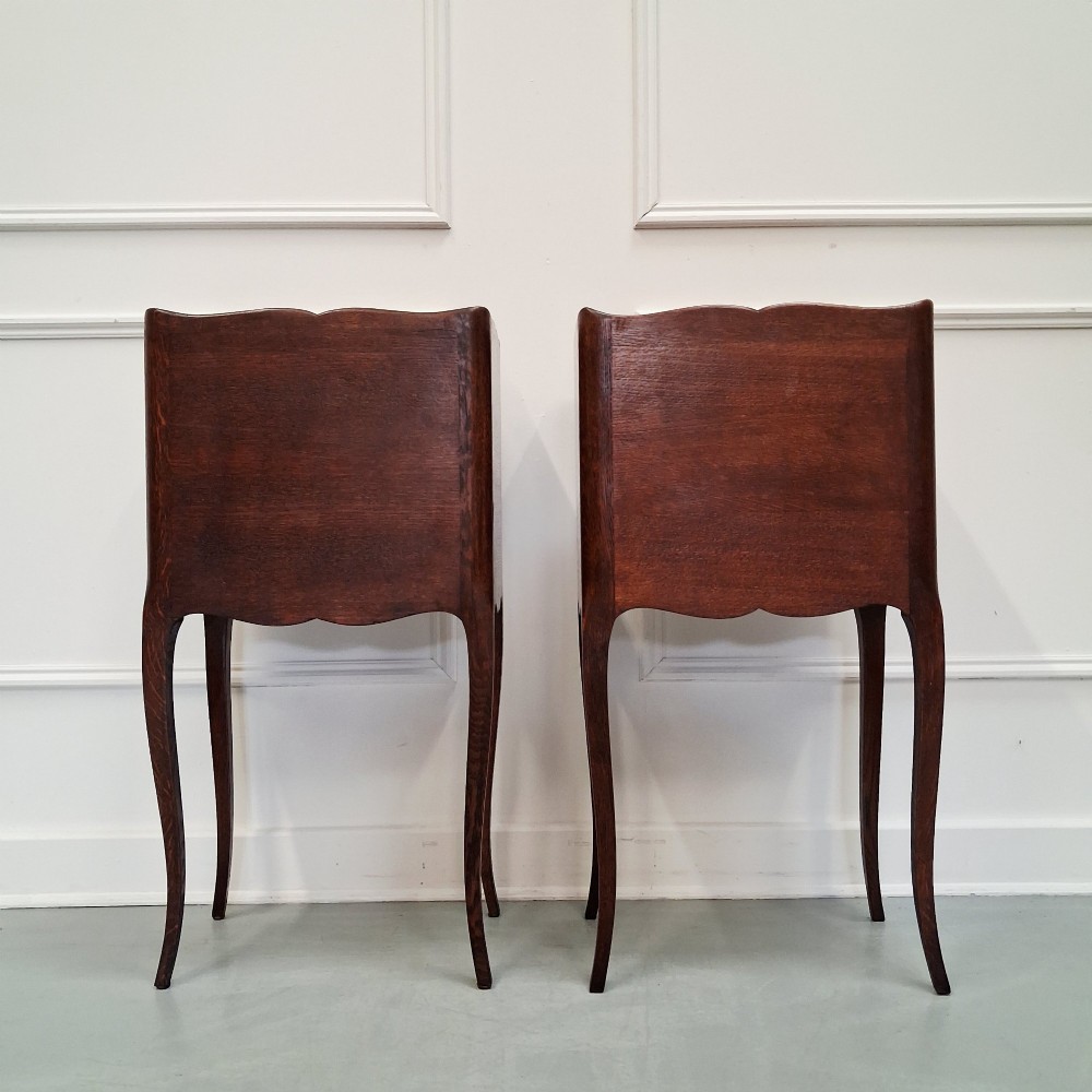 A pair of 1930s French oak bedside tables with slender cabriole legs, one featuring three drawers and the other featuring a single drawer above an open compartment. View IV