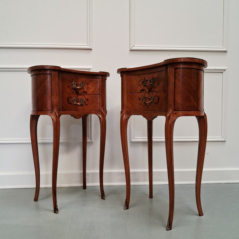 A pair of slender French style kingwood bedside cabinets featuring marquetry floral inlay, two drawers with brass handles, and tall cabriole legs. View II
