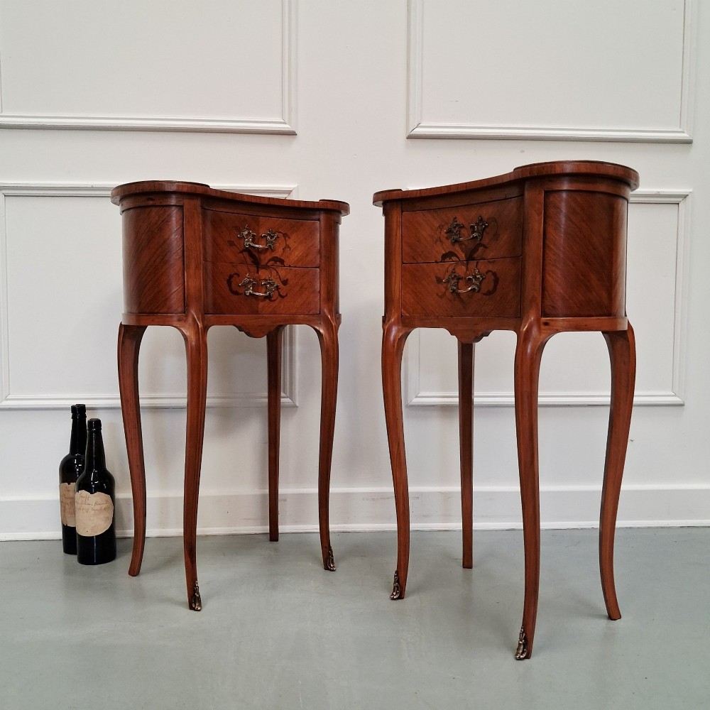 A pair of slender French style kingwood bedside cabinets featuring marquetry floral inlay, two drawers with brass handles, and tall cabriole legs. View III