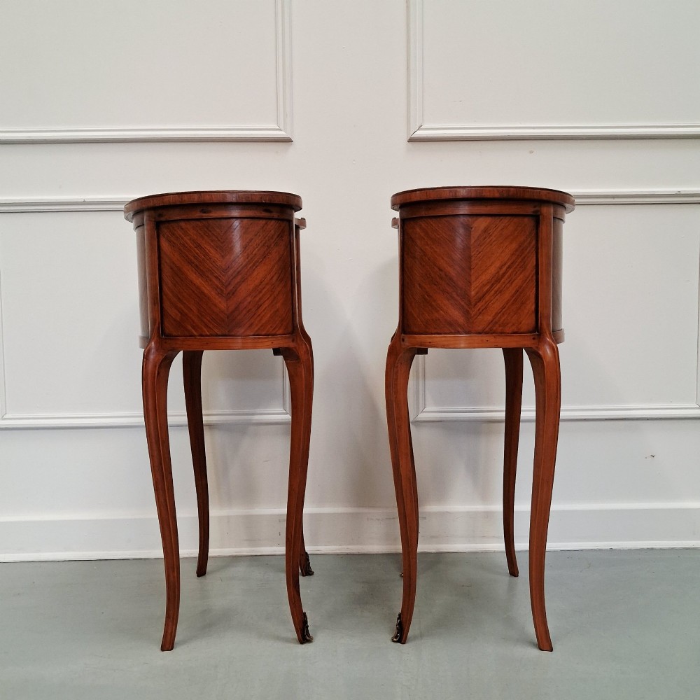 A pair of slender French style kingwood bedside cabinets featuring marquetry floral inlay, two drawers with brass handles, and tall cabriole legs. View IV