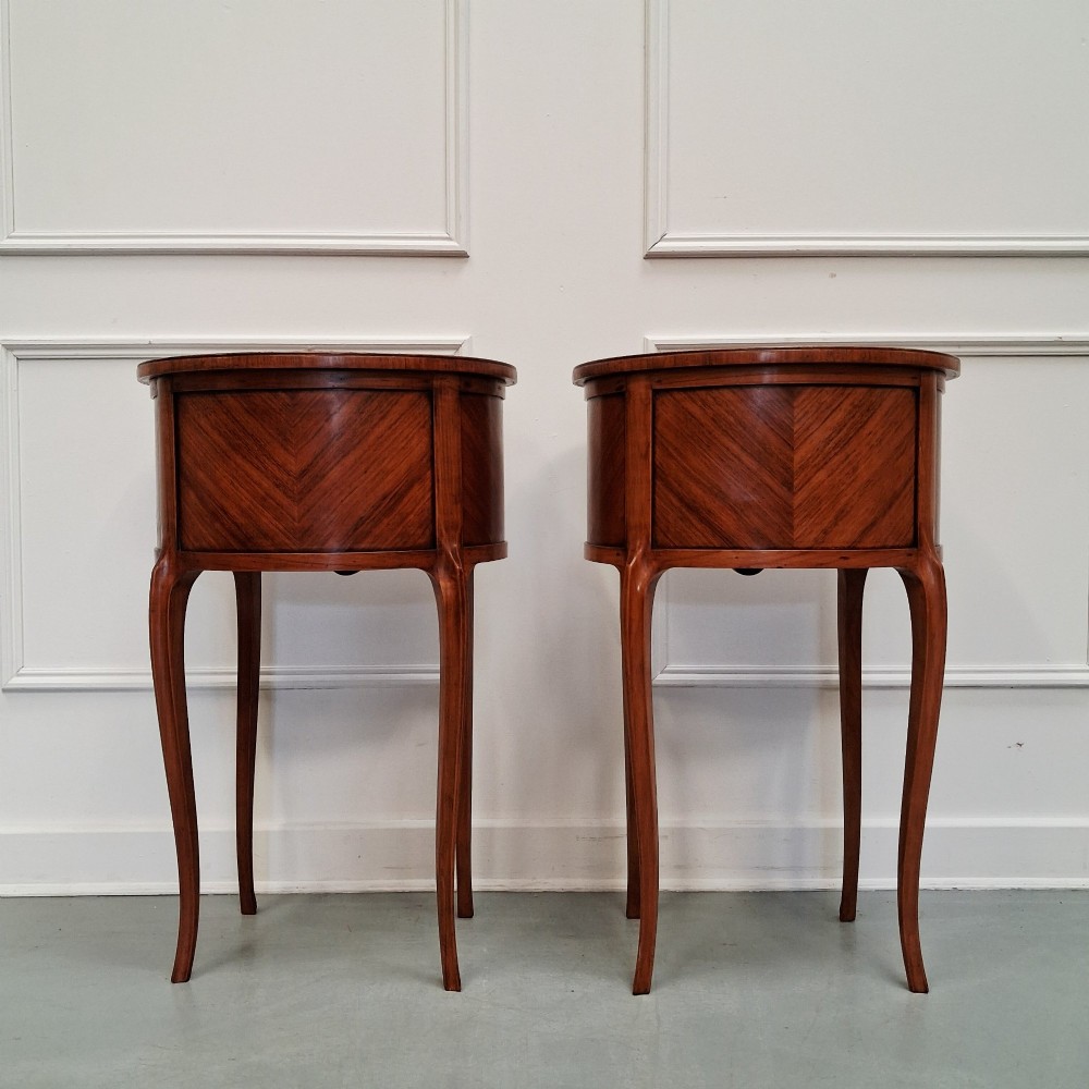 A pair of slender French style kingwood bedside cabinets featuring marquetry floral inlay, two drawers with brass handles, and tall cabriole legs. View V