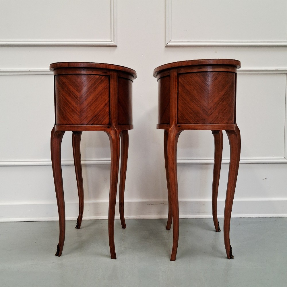 A pair of slender French style kingwood bedside cabinets featuring marquetry floral inlay, two drawers with brass handles, and tall cabriole legs. View VI