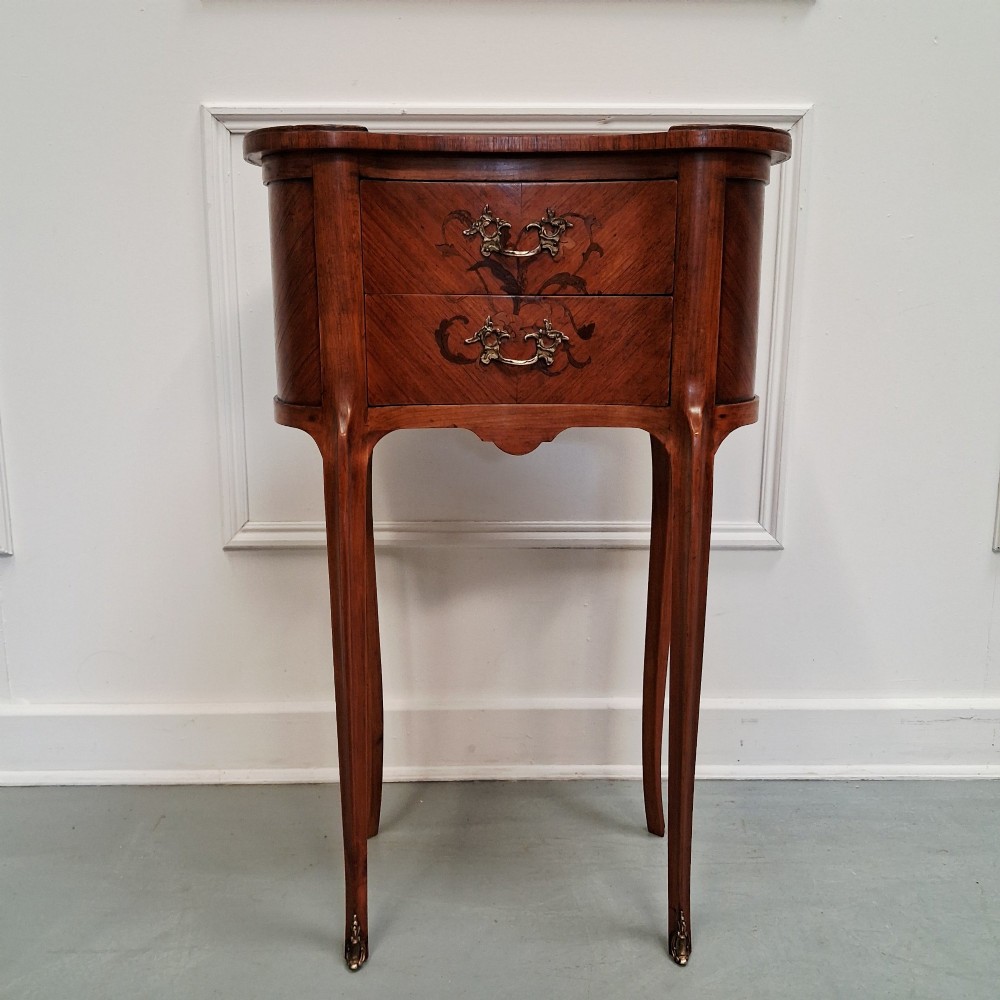 A pair of slender French style kingwood bedside cabinets featuring marquetry floral inlay, two drawers with brass handles, and tall cabriole legs. View VII