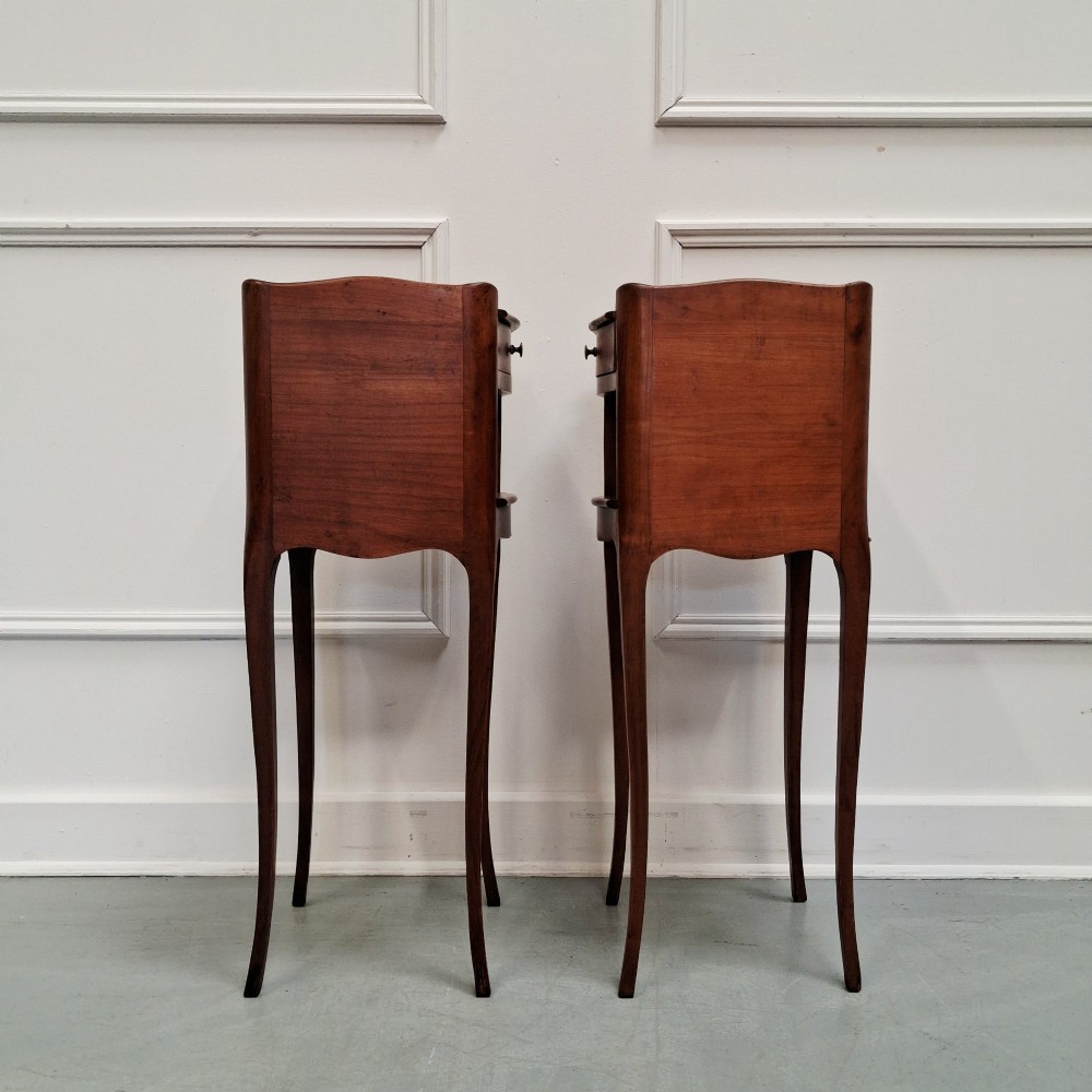 A pair of tall French cherry wood bedside tables featuring single frieze drawers, open compartments, and slender cabriole legs. View IV