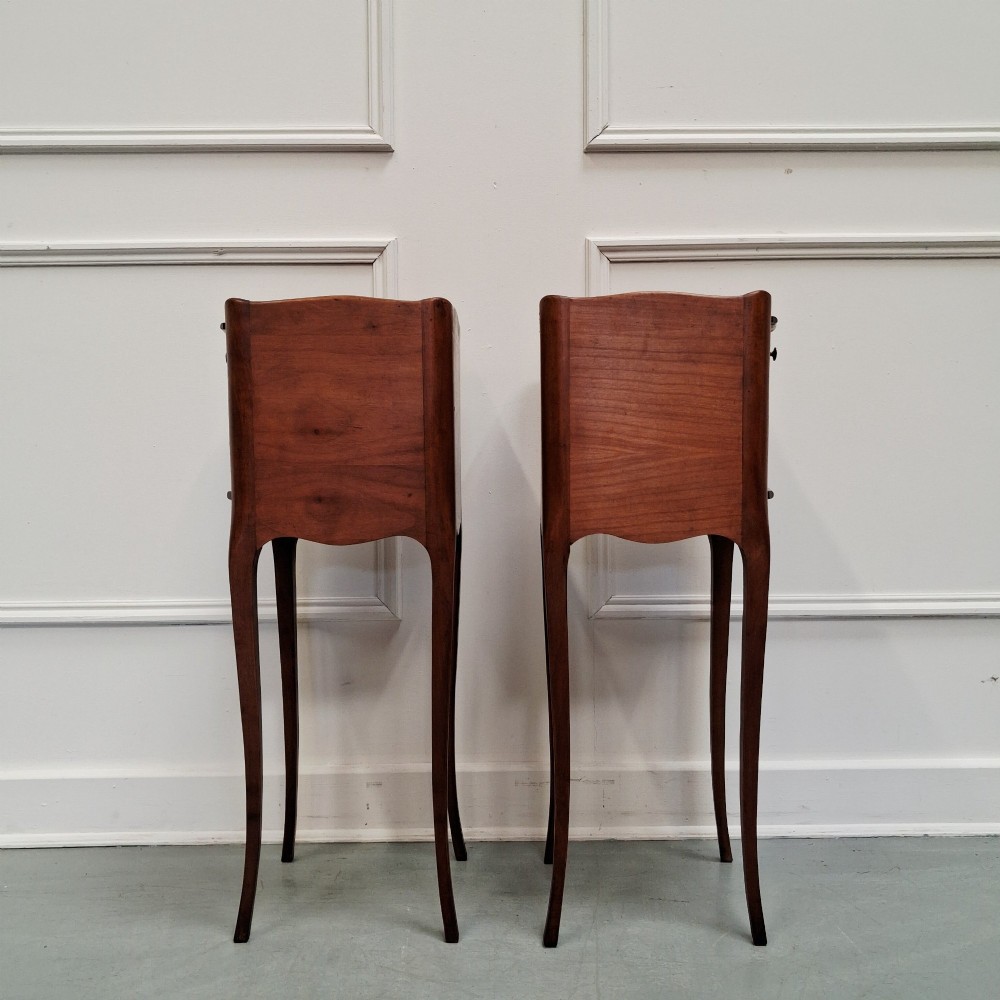 A pair of tall French cherry wood bedside tables featuring single frieze drawers, open compartments, and slender cabriole legs. View VI