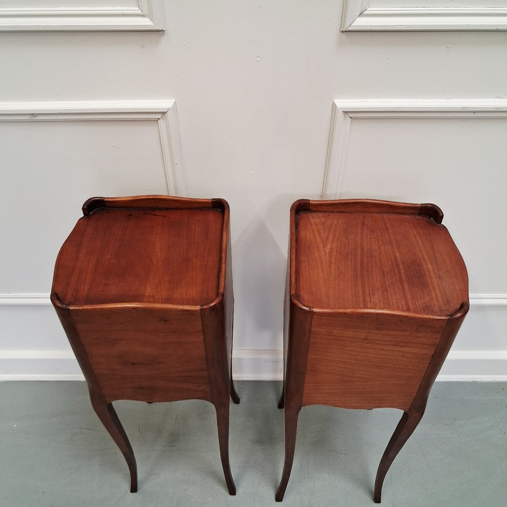 A pair of tall French cherry wood bedside tables featuring single frieze drawers, open compartments, and slender cabriole legs. View VII