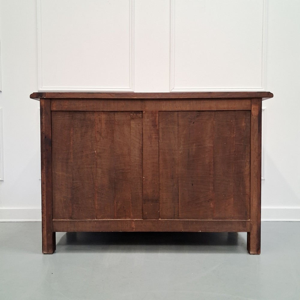 A French country walnut commode featuring three full-width drawers with ornate brass hardware and a scalloped lower apron. View IX