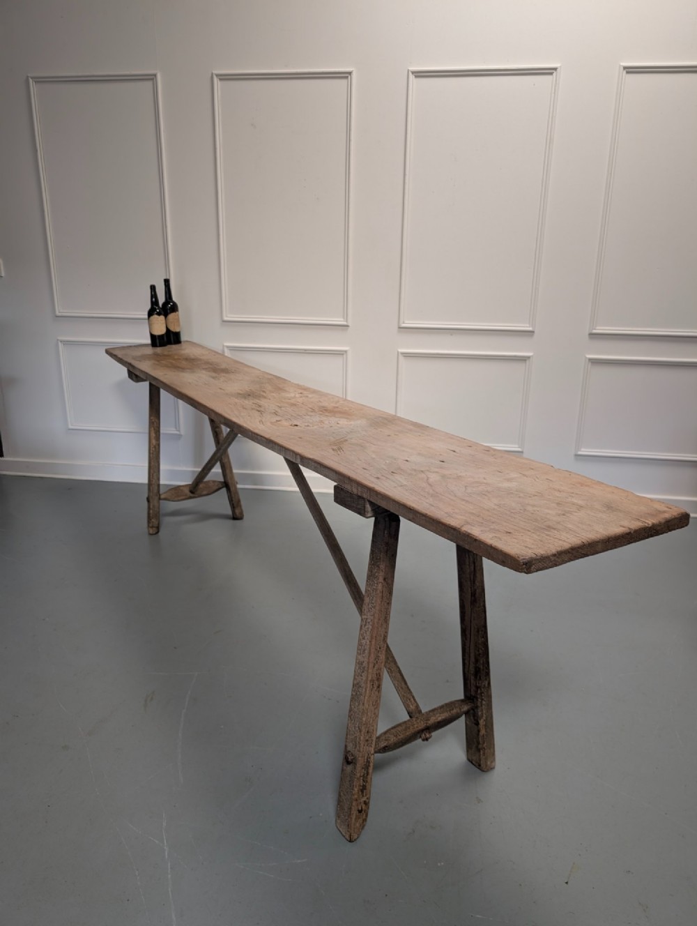 An exceptionally long, narrow 19th-century French wooden laundry table featuring A-frame legs and diagonal structural supports. View II