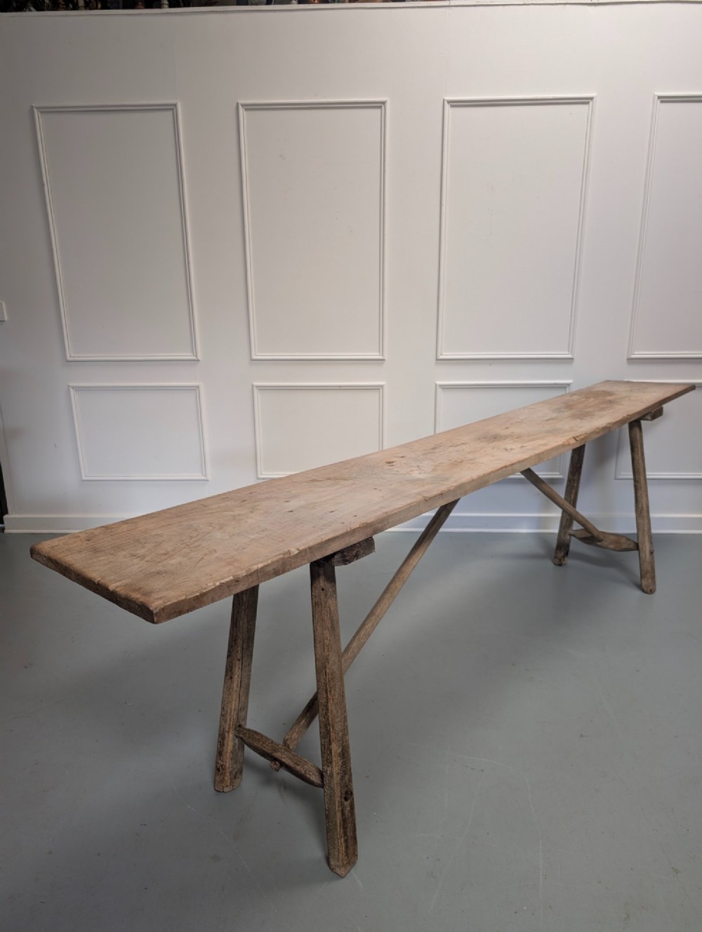 An exceptionally long, narrow 19th-century French wooden laundry table featuring A-frame legs and diagonal structural supports. View IV