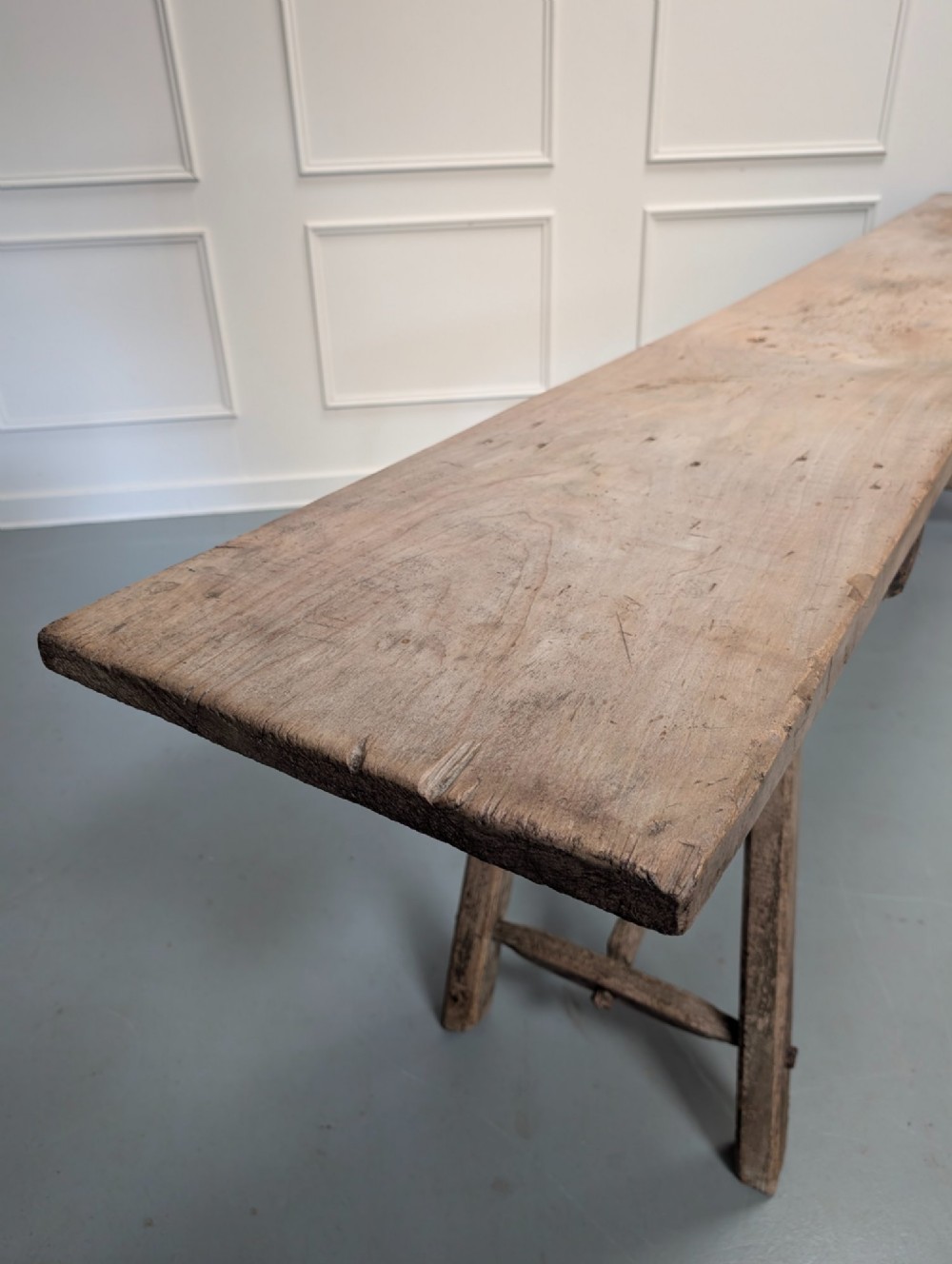 An exceptionally long, narrow 19th-century French wooden laundry table featuring A-frame legs and diagonal structural supports. View V