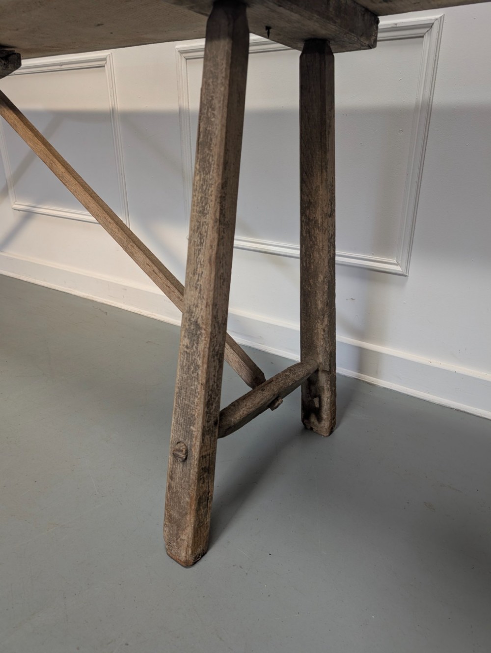 An exceptionally long, narrow 19th-century French wooden laundry table featuring A-frame legs and diagonal structural supports. View VII