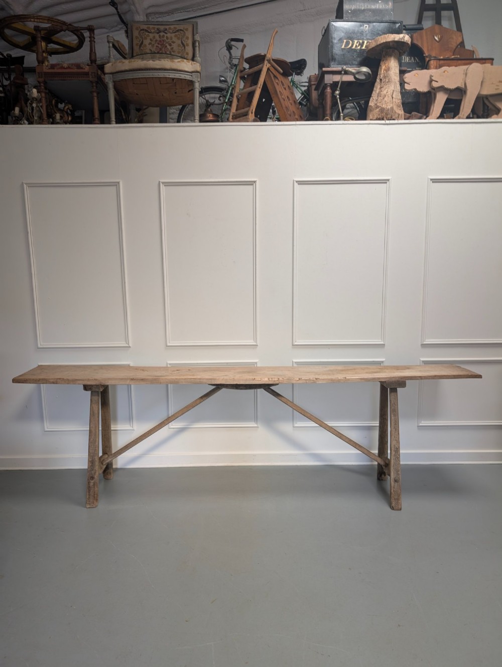 An exceptionally long, narrow 19th-century French wooden laundry table featuring A-frame legs and diagonal structural supports.