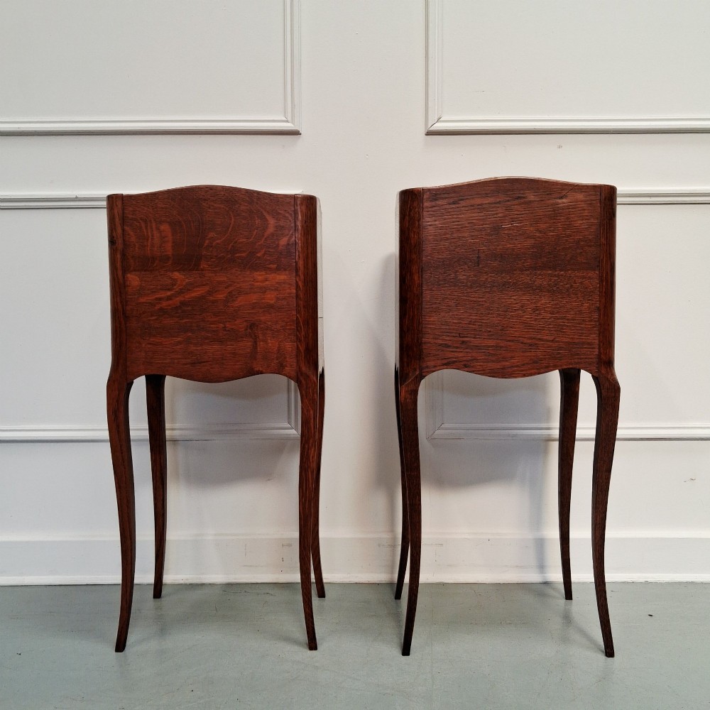 A matching pair of tall French oak bedside tables with slender cabriole legs, three drawers each, and metal knobs. View VI