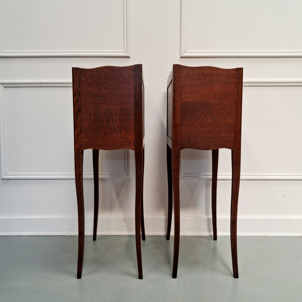 A pair of tall French oak bedside tables featuring single top drawers, open storage alcoves, scalloped aprons, and slender curved cabriole legs. View IV