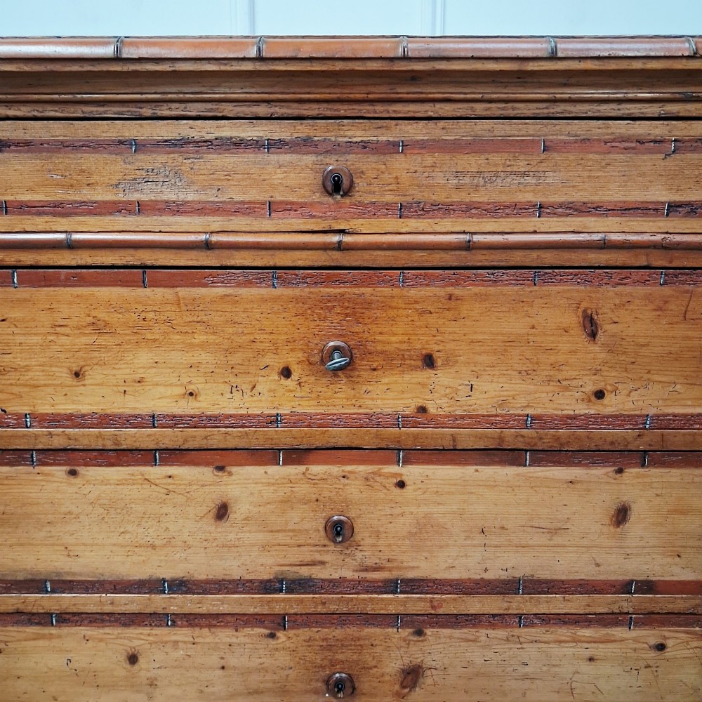 A tall 19th-century French wooden semainier chest featuring seven drawers framed by turned faux bamboo mouldings and supported by bun feet. View II