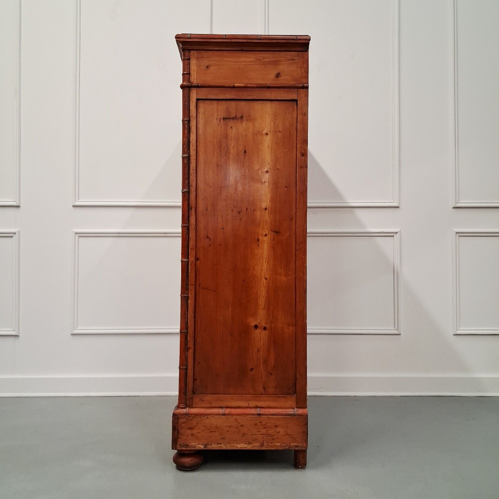 A tall 19th-century French wooden semainier chest featuring seven drawers framed by turned faux bamboo mouldings and supported by bun feet. View VII
