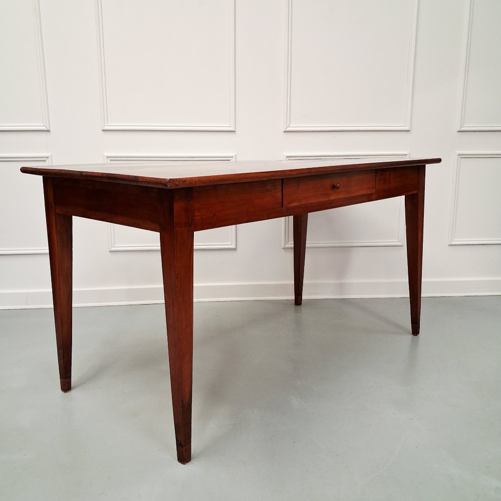 A late 19th-century French farmhouse dining table constructed from warm cherry wood featuring square tapered legs and an integrated frieze drawer. View V
