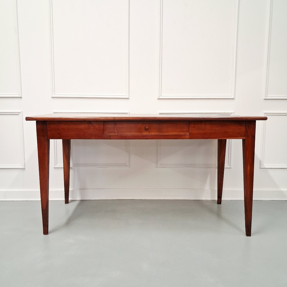 A late 19th-century French farmhouse dining table constructed from warm cherry wood featuring square tapered legs and an integrated frieze drawer. View VII