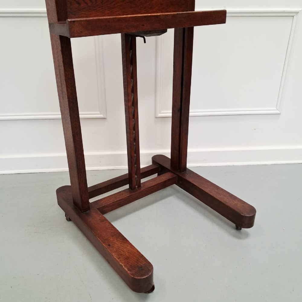 A dark oak French studio easel from circa 1890 featuring an adjustable vertical shaft, horizontal support shelf, and caster feet. View II