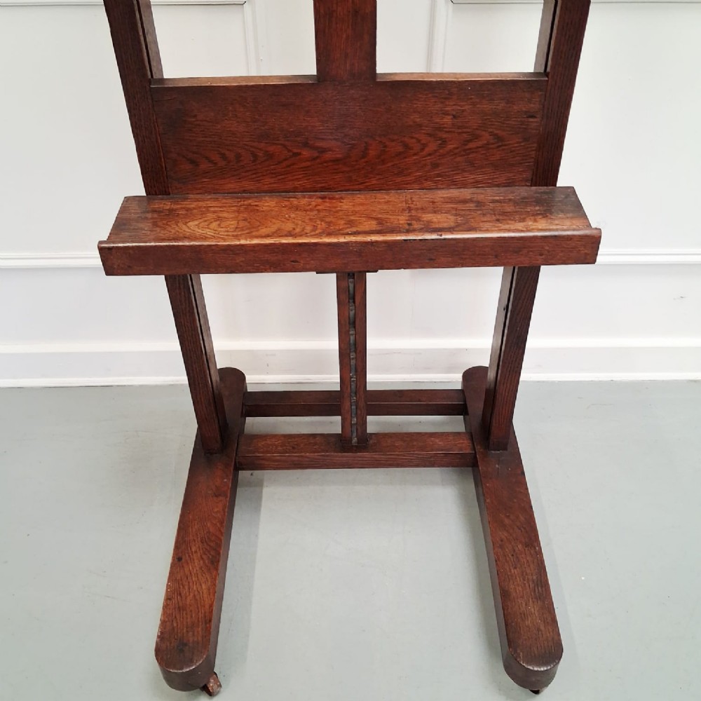A dark oak French studio easel from circa 1890 featuring an adjustable vertical shaft, horizontal support shelf, and caster feet. View III